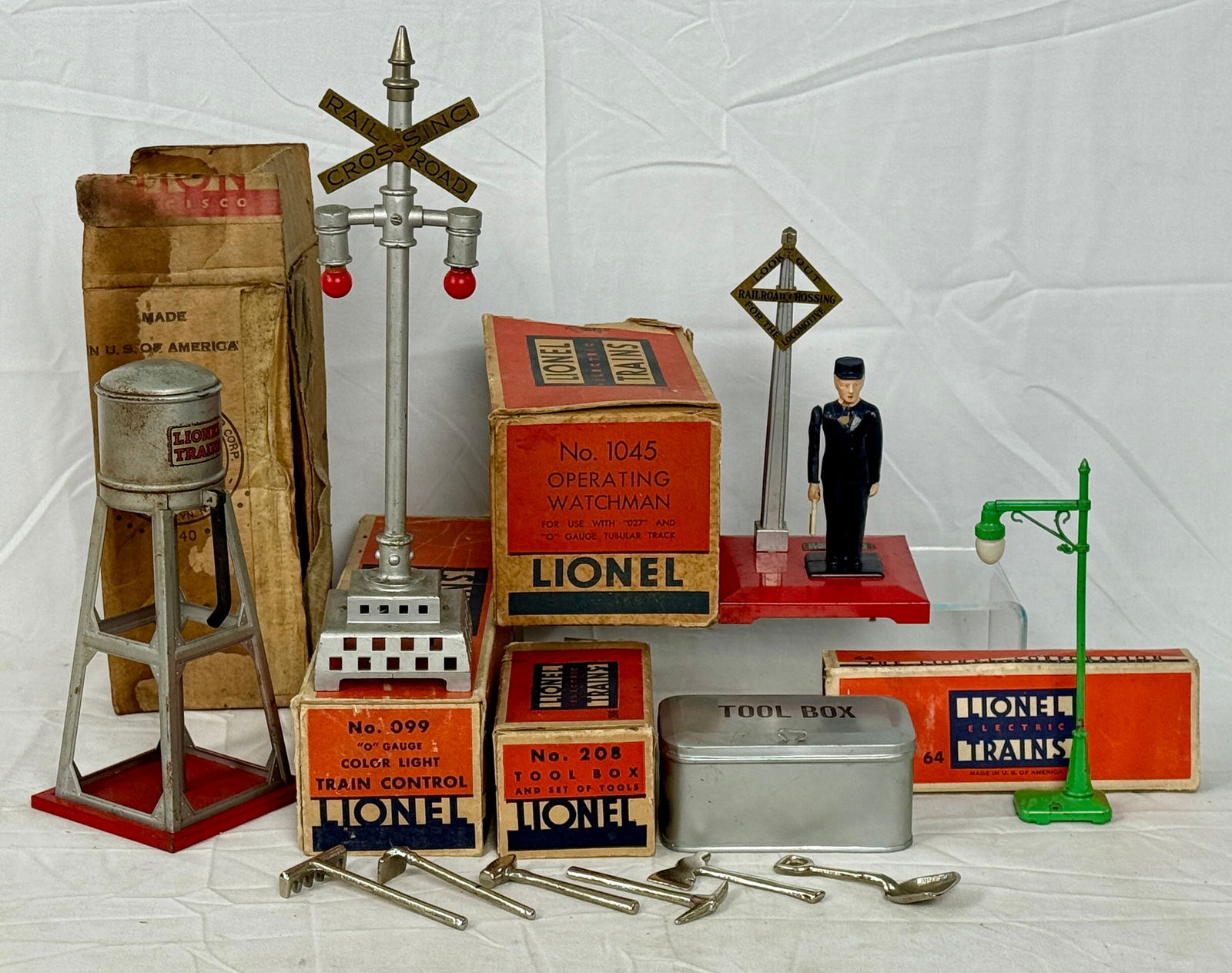 5 Lionel O Gauge Train Accessories: No. 1045 Operating Watchman, No. 099 silver Train Control signal with two red lights, No. 93 silver water tower , green No. 64 streetlamp. and a No. 208 Tool box and tools, Original boxe