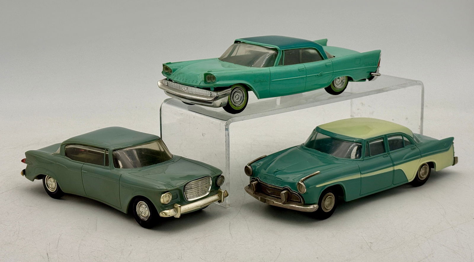 Three Jo Han Promo Automobiles: 1956 De Soto Fireflight two tone coaster, 1958 Chrysler New Yorker with torsion bars two tone coaster, 1959 Studebaker Lark gray friction not working all have minor warp C7-8.