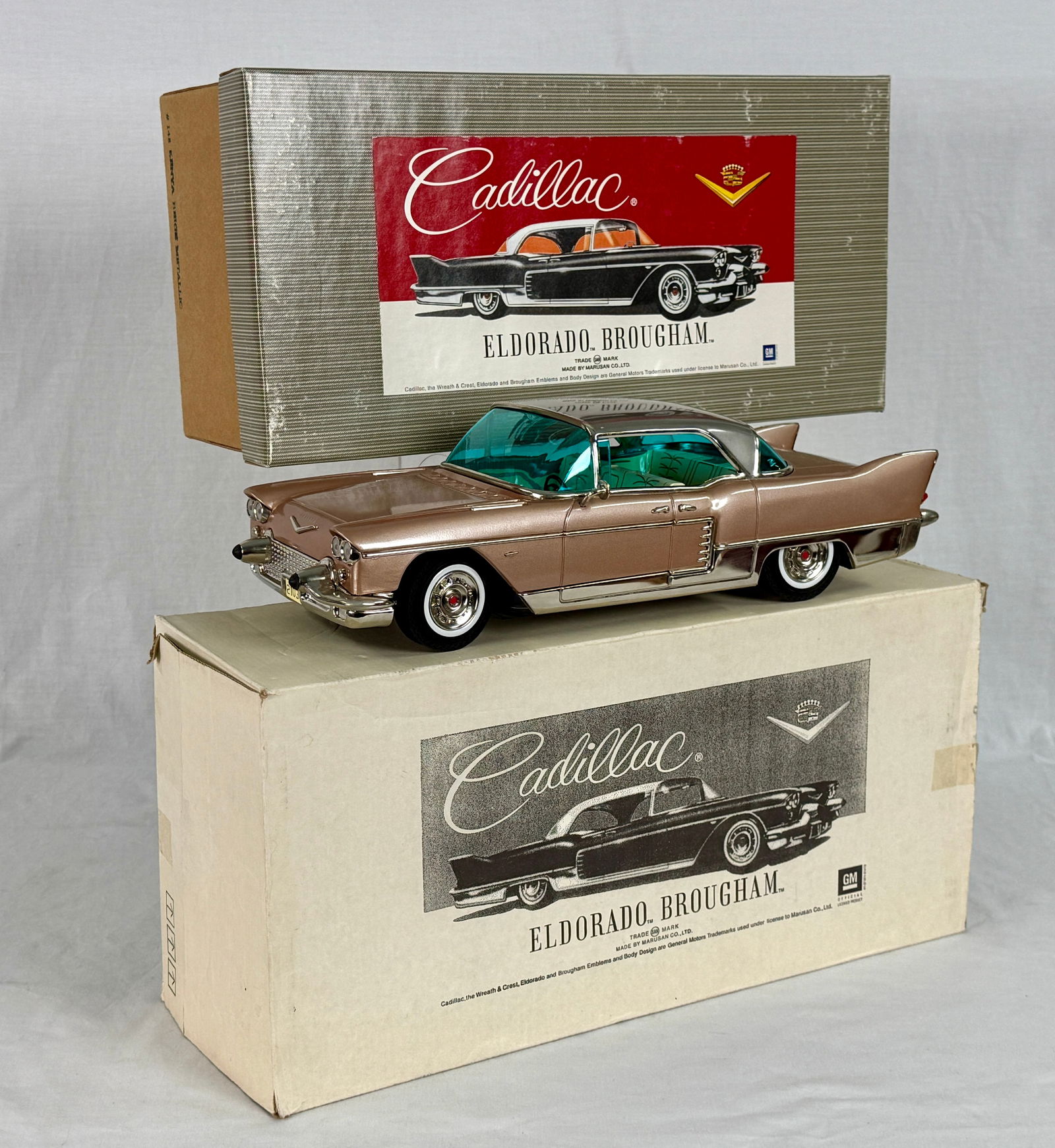 A Marusan 1957 Cadillac Eldorado Brougham Tin Model Car: A 1957 Cadillac Eldorado Brougham toy car, presented with two boxes labeled "Cadillac ELDORADO BROUGHAM", "MADE BY MASUDAYA TOY LTD.", "MADE IN JAPAN", Litho tin 148 Kenya beige metallic 14 1/2 inches