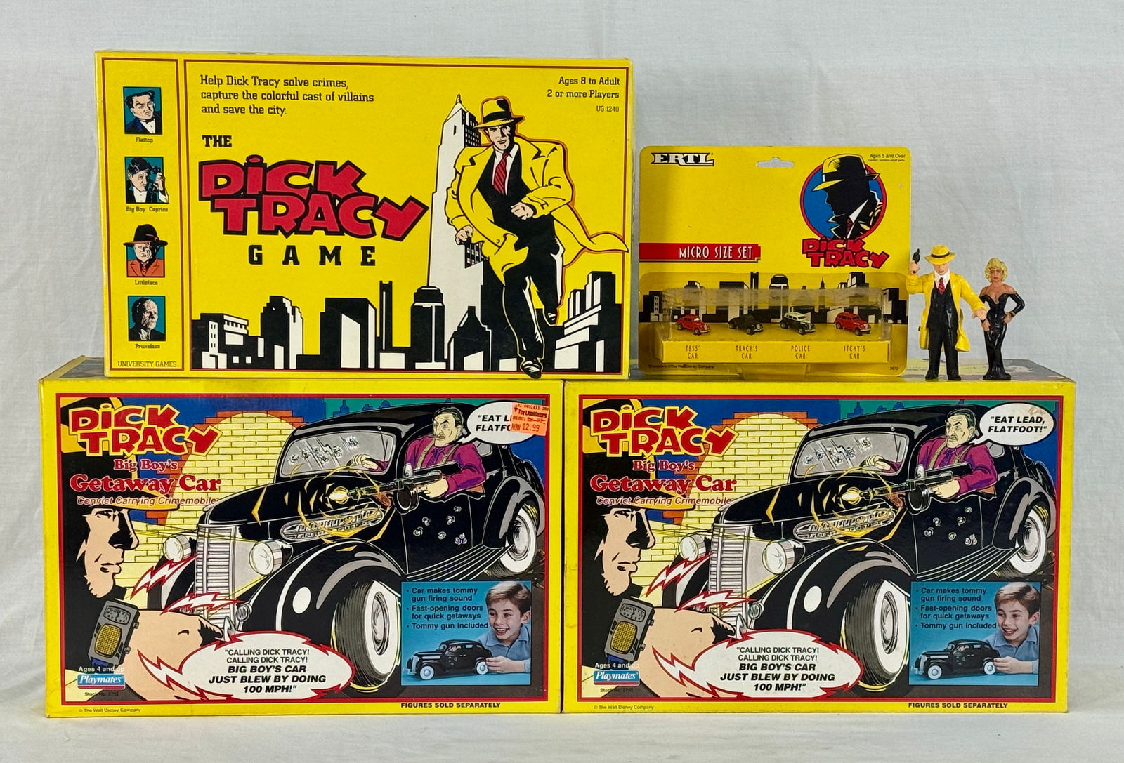 A Collection of Playmates Dick Tracy Game & Toys: A yellow "THE DICK TRACY GAME" board game, an "ERTL DICK TRACY MICRO SIZE SET" of four red micro-size cars on a blister card, two loose Dick Tracy and female action figures, and two identical "DICK TR