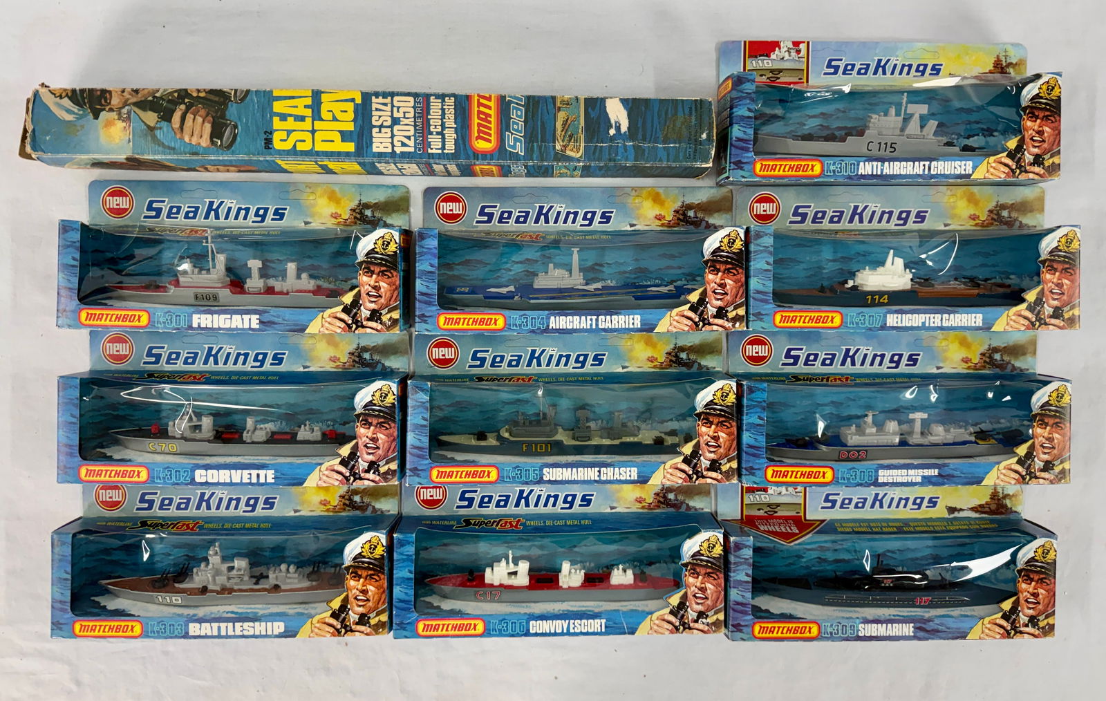 Matchbox Sea Play Mat and Ten Sea Kings Superfast Toy Ships: One Matchbox "Sea Play" mat box missing end flaps, 120x50 centimetres, and ten individually packaged Matchbox "Sea Kings Superfast" toy ships, K-301 thru K-310 original boxes minor wear most hangar ho