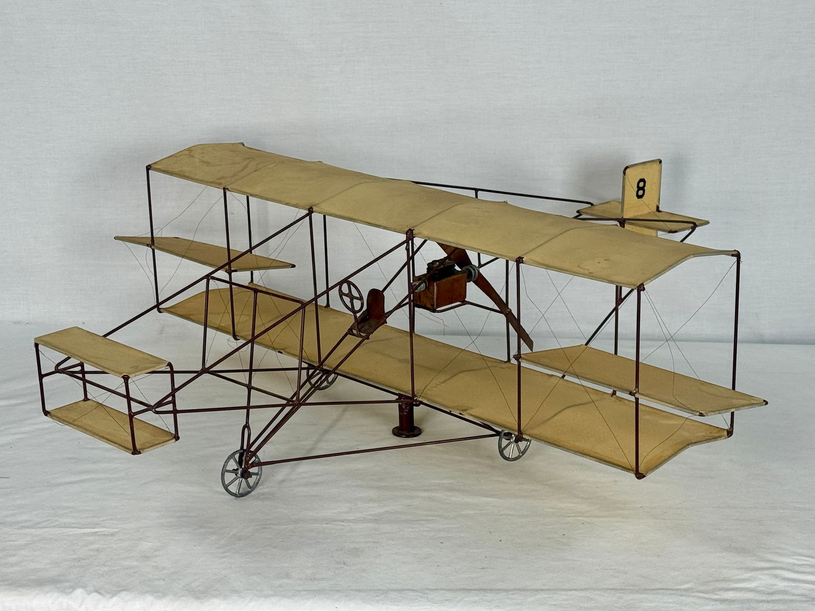 Wright-Style Model Biplane: Steel rod and fabric construction 34 inches long with 36 inch wing span and 11 inches tall, with a pole receiver on the base for easy display, C8-9.