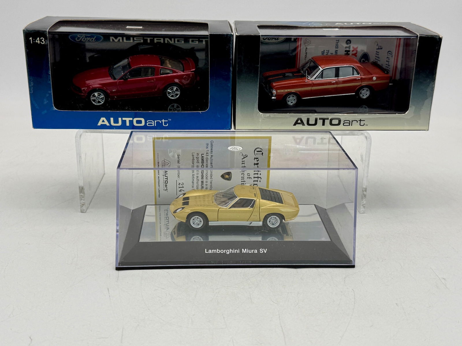 3 AUTOart 1:43 Scale Resin Model Cars: A trio of AUTOart 1:43 scale resin model cars including a Ford Mustang GT 52762, a Ford Falcon XY GTHO 52700, and a gold Lamborghini Miura SV 54545 in original boxes. OB and inserts C9.