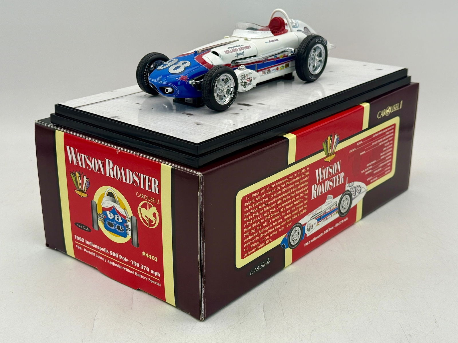 Carousel 1 1:18 1962 Watson Roadster #98 Die-Cast Model: A 1:18 scale Carousel 1 die-cast model of the #98 Agajanian Willard Battery Special 1962 Watson Roadster in white, blue, and red, complete with original packaging and a Certificate of Authenticity. 9