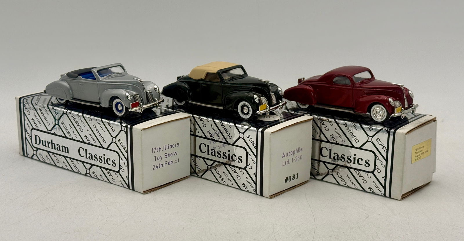 3 Durham Classics Lincoln Zephyr Die-Cast Model Cars: A trio of 1/43 scale die-cast Lincoln Zephyr models in silver, black, and maroon, featuring commemorative labels for the Illinois Toy Show and Autophile Ltd. All are show specials. C9