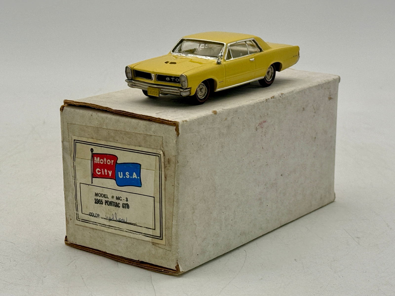 Motor City U.S.A. MC-3 1965 Pontiac GTO Die-Cast Model: A yellow Motor City U.S.A. model # MC-3 1965 Pontiac GTO die-cast car with its original labeled box. white metal 1:43 scale. OB mw C9
