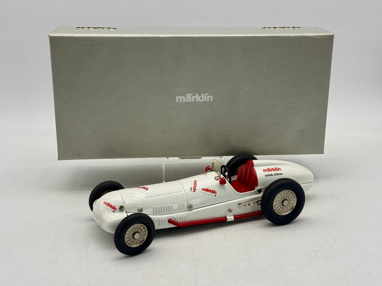Marklin Alpha Toy Racing Car W125 with Silver Presentation Box: A white Marklin Alpha toy racing car featuring red accents and interior, accompanied by a silver presentation box labeled ALPHA-AUTO. Painted 10 10 1/2 inches long CW/W w/key OB mw C9.