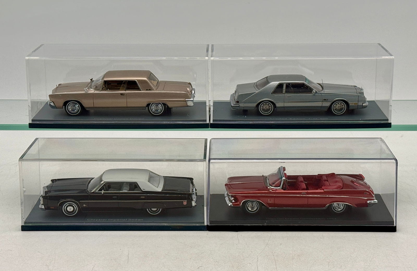 4 NEO Imperial Model Cars: A collection of four die-cast model cars in clear display cases featuring a tan Imperial Crown Coupe, a silver limited edition Imperial Coupe, a black and white Chrysler Imperial Sedan, and a red 1963