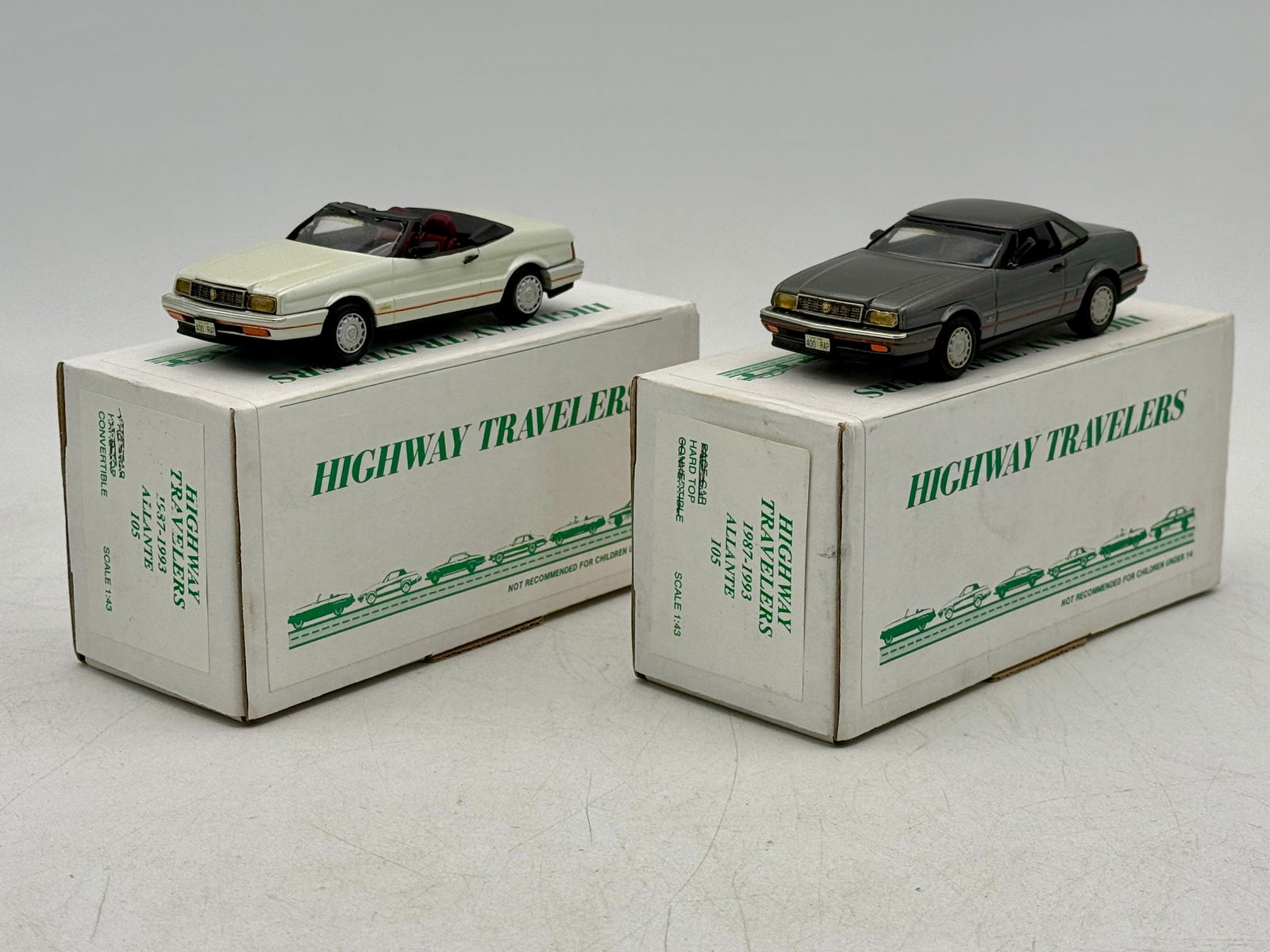 2 Highway Travelers Cadillac Allante Model Cars: A pair of Highway Travelers 1:43 scale model #105 Cadillac Allante cars in white convertible and grey hardtop versions, housed in their original 1987-1993 Allante. Top up or top down accessories. OB's