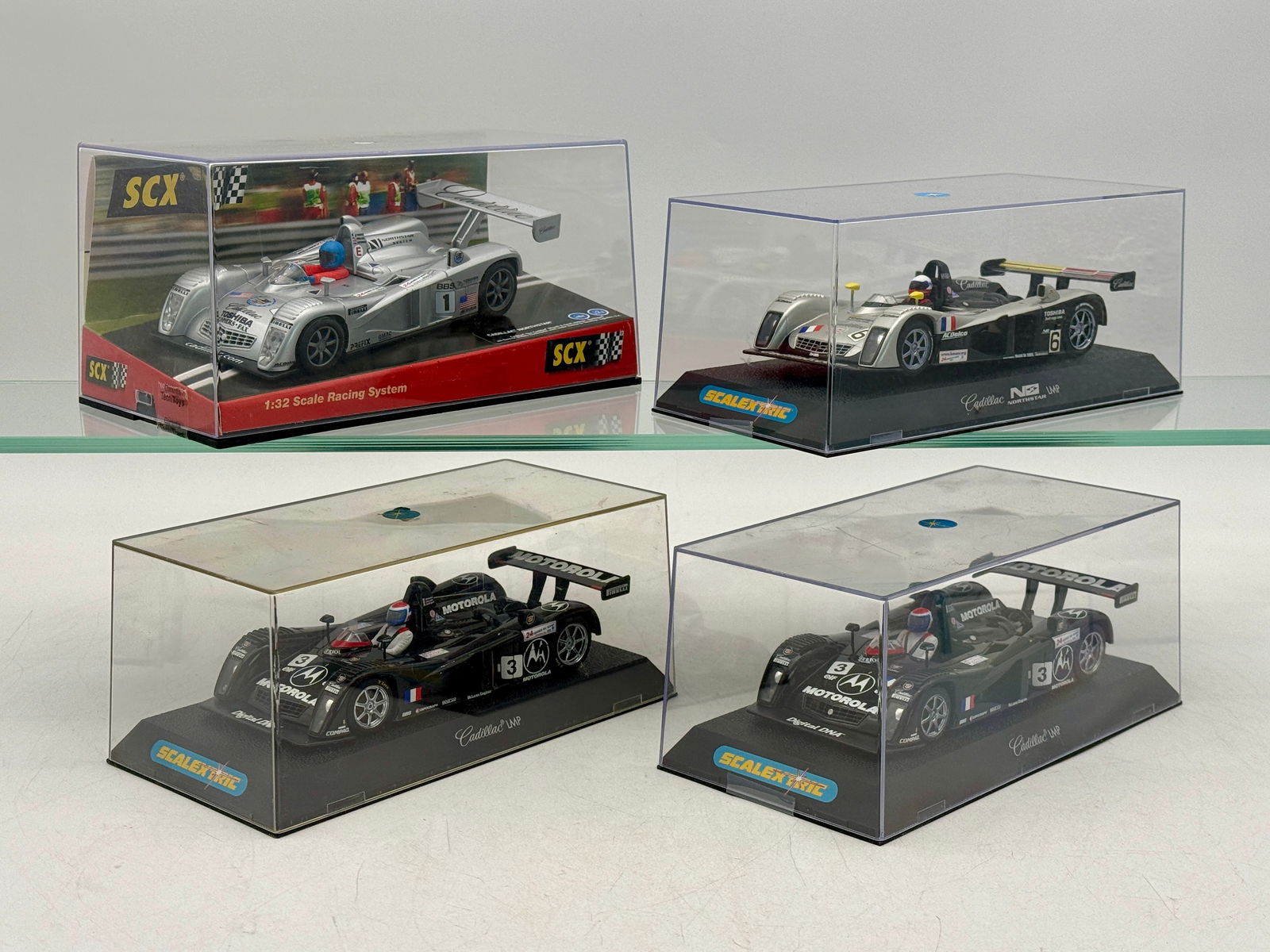 A Collection of SCX and Scalextric Cadillac Northstar Slot Cars: A collection of 1:32 scale Cadillac Northstar LMP slot cars featuring silver and black liveries with SCX and Scalextric branding original boxes C9.