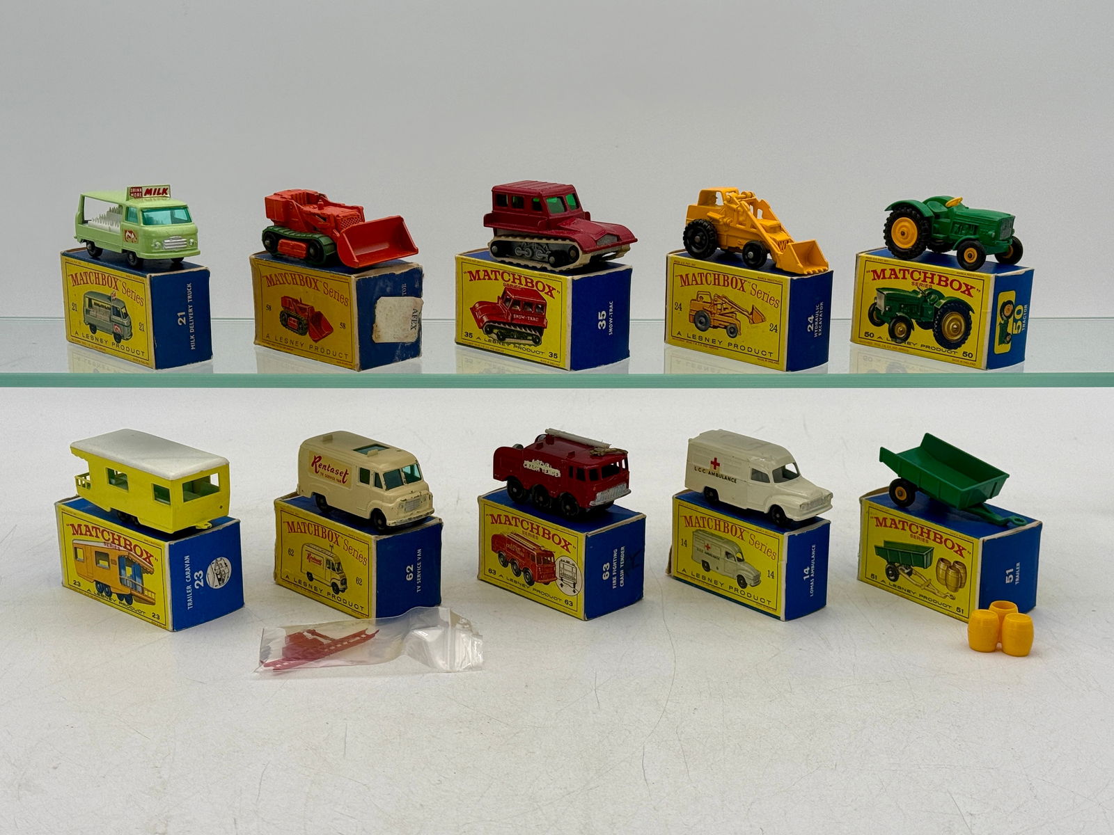 10 Lesney Matchbox Series Die-Cast Vehicles: 10. Matchbox vehicles, 24B2 excavator, 50B2 tractor, 51B2 trailer, 23D1 caravan, 14C3 ambulance, 63B2 crash truck with worn side lettering, 62B2 TV truck complete, 21C8 milk truck, 35B2 snow track, 58