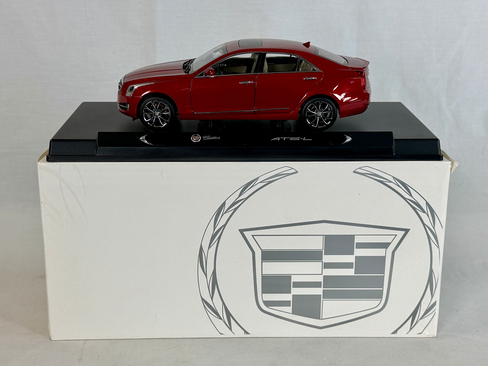 1/18 Cadillac ATS-L Dealer promo Model Car: A 1/18 scale resin red Cadillac ATS-L die-cast metal model car featuring a sunroof and tan interior, mounted on a black display base with its original branded box. 9.25" long OB mw C9.