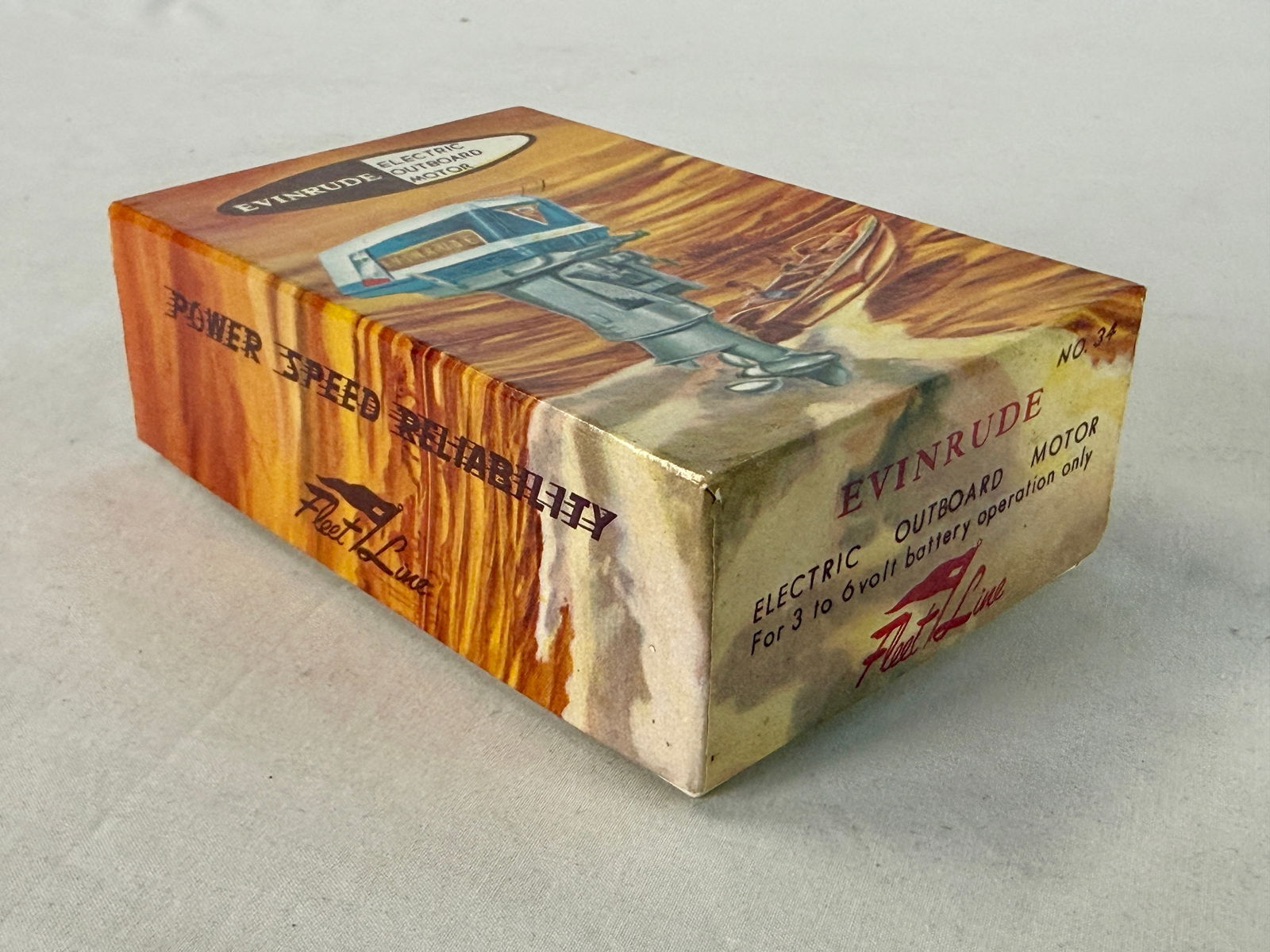 A Collection of 1959 Evinrude Lark Outboard Motor and Box: A blue, white, and silver #34 Evinrude Lark 35 HP electric outboard model motor accompanied by its original Fleet Line illustrated box and a K & O Models, Inc. instruction manual, C10.