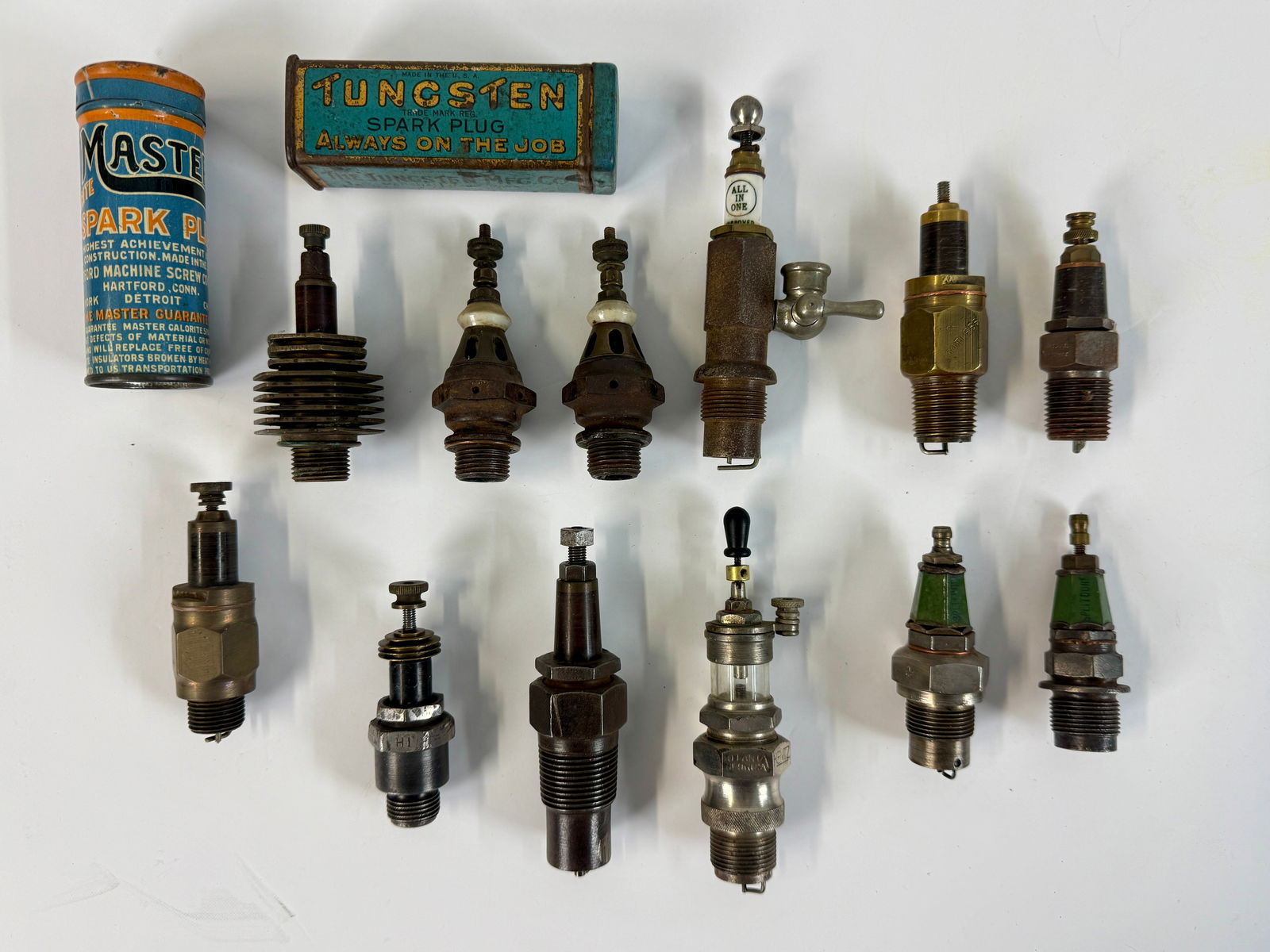 A Collection of 12 Early Vintage Spark Plugs and Containers (1 of 2)