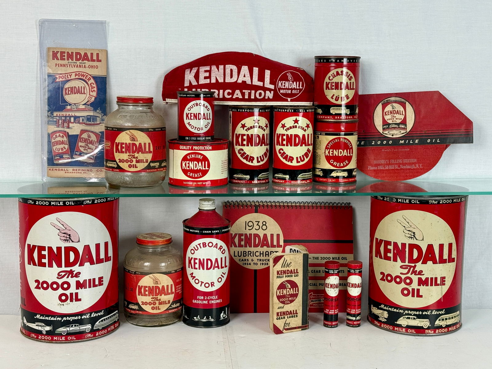 A Collection of Vintage Kendall Motor Oil Advertising and Containers: A collection of vintage Kendall Motor Oil advertising items and product containers including metal cans, glass jars, and a 1938 Lubrichart featuring the Bradford, Pennsylvania brand's signature graphi