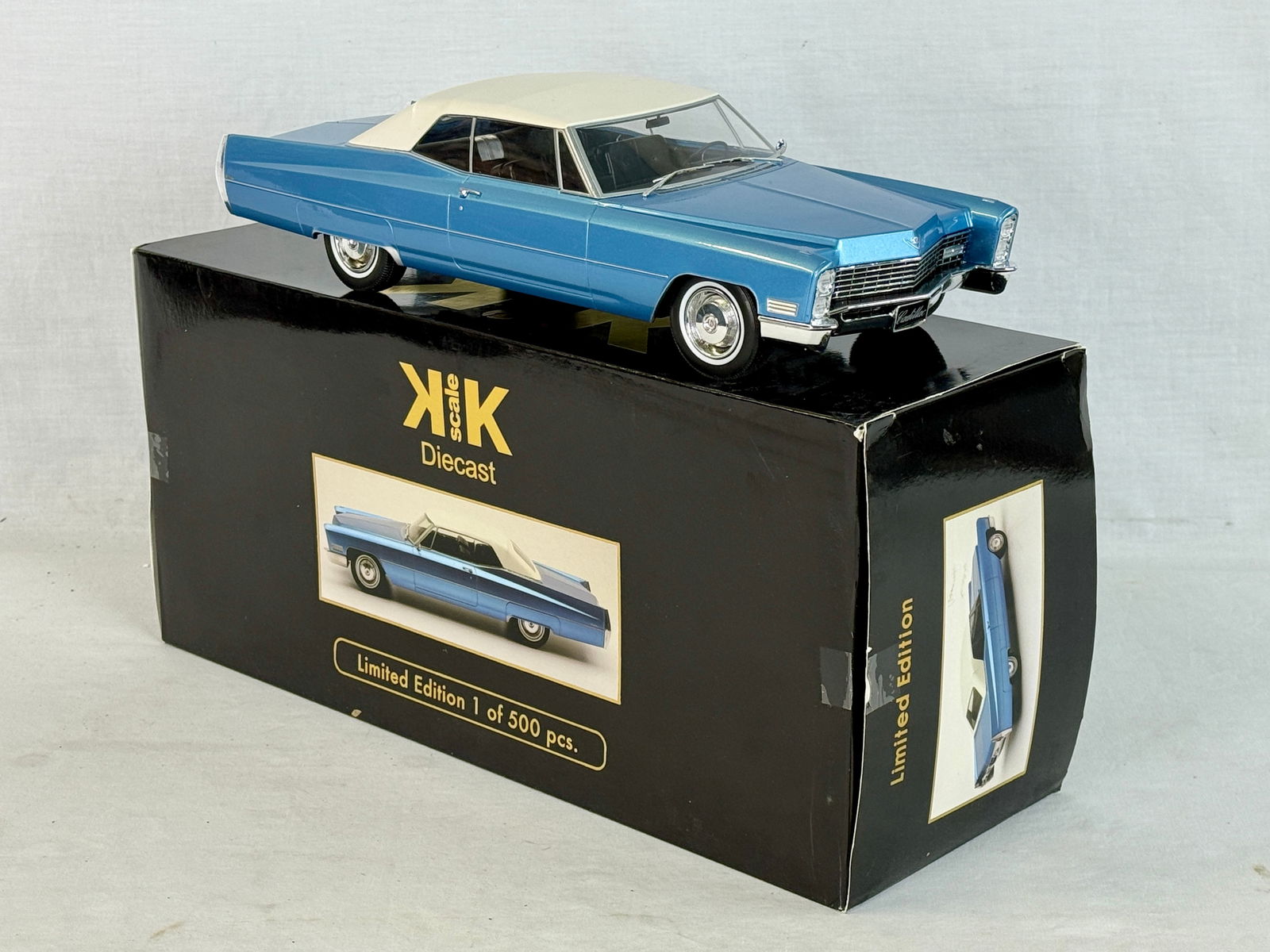 KK Scale 1:18 1967 Cadillac DeVille Soft Top Model Car: A metallic blue and white resin 1:18 scale die-cast 1967 Cadillac DeVille model car by KK scale featuring a soft top and original limited edition packaging C9.