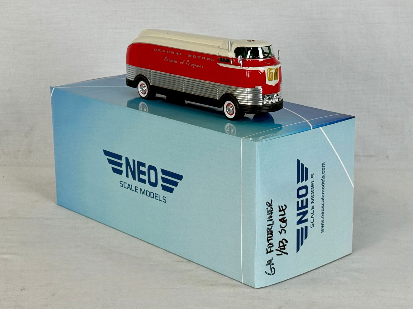 NEO Scale Models 1:43 1941 GM Futurliner Parade of Progress: A red, white, and silver 1:43 scale resin model of a 1941 GM Futurliner Parade of Progress by NEO Scale Models with its original collector box C9.