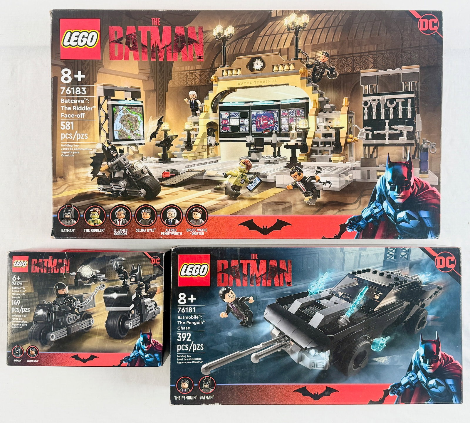 Three LEGO DC The Batman Building Sets Including Batcave 76183 Batmobile 76181 and Motorcycle: This lot features a collection of three plastic LEGO building sets based on the 2022 film The Batman. The first set is LEGO 76183 Batcave: The Riddler Face-off, a 581-piece set featuring the Batcave a