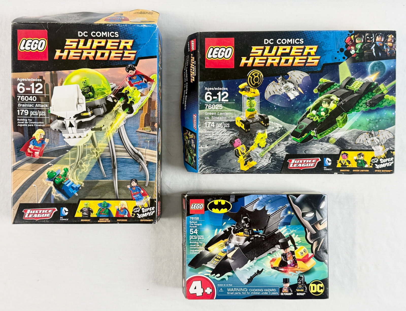 Three LEGO DC Comics Super Heroes Building Sets 76040 76025 and 76158: A collection of three LEGO DC Comics Super Heroes building sets, including Brainiac Attack (Set 76040), Green Lantern vs. Sinestro (Set 76025), and Batboat The Penguin Pursuit! (Set 76158). As indicat