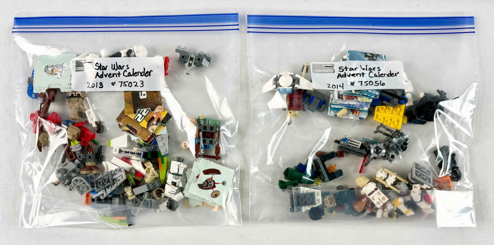 A Pair of LEGO Star Wars Advent Calendar Sets 75023 and 75056: This lot comprises two loose LEGO Star Wars Advent Calendar sets from 2013 and 2014. Set 75023, released in 2013, includes several micro-scale ships and landscape builds along with minifigures such as