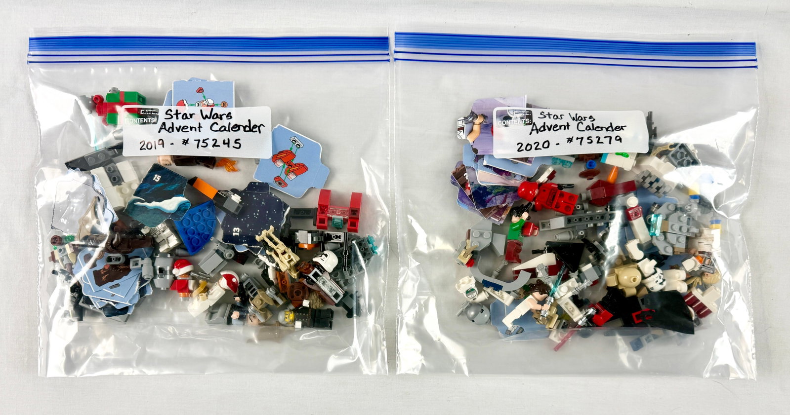 A Pair of LEGO Star Wars Advent Calendar Sets: This lot consists of two loose LEGO Star Wars advent calendar sets, organized into separate plastic bags. Based on the handwritten labels and specific components, these are identified as the 2019 LEGO