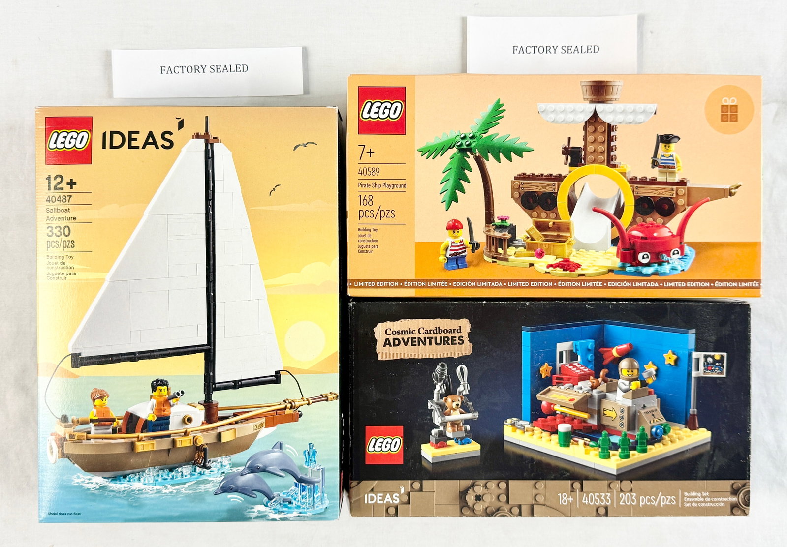 Three LEGO Construction Sets Including Sailboat Adventure, Pirate Ship Playground, and Cosmic: This lot features a trio of LEGO construction sets from the Ideas and Limited Edition product lines. The first set is LEGO Ideas 40487 Sailboat Adventure, which includes 330 pieces and is recommended 