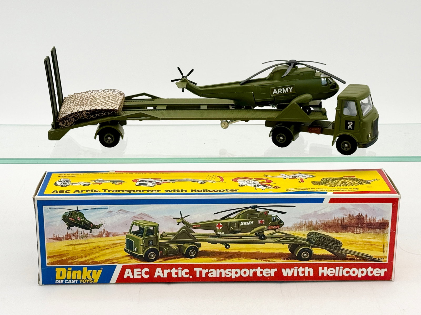 Dinky Toys 618 AEC Artic. Transporter with Helicopter and Box: Dinky Toys No. 618 AEC Articulated Transporter with Helicopter set including original illustrated packaging. The die-cast military ensemble features an olive green AEC tractor unit, low-loader trailer