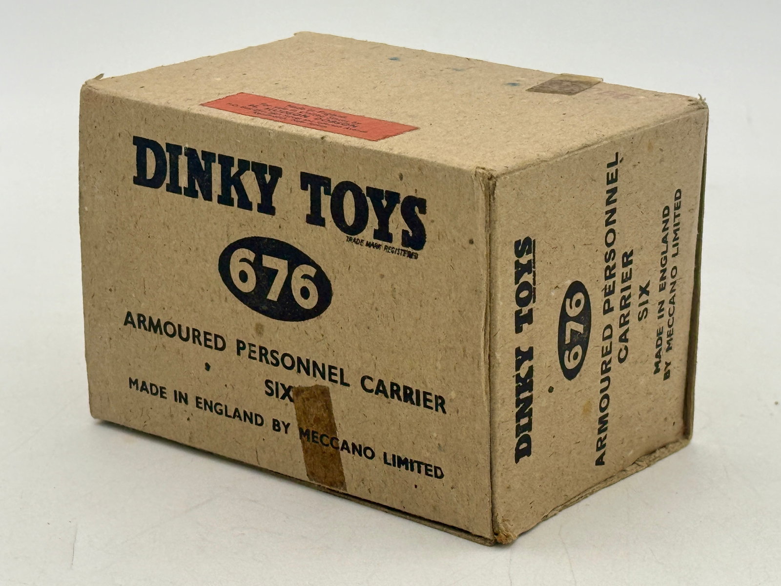 Trade box of 5 Dinky Toys No. 676 Armored Personnel Carriers: A collection of Dinky Toys No. 676 Armored Personnel Carriers produced by Meccano Limited. Each die-cast vehicle is finished in an olive drab color and features a rotating turret with six wheels. The 