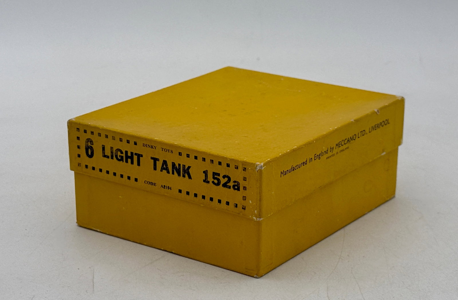 6 Dinky Toys 152a Light Tanks in Original Trade Box: Six Dinky Toys 152a light tanks manufactured by Meccano Ltd. in England. Each die-cast model is finished in matte olive drab paint and features a rotating turret and wire antenna. The set is housed in