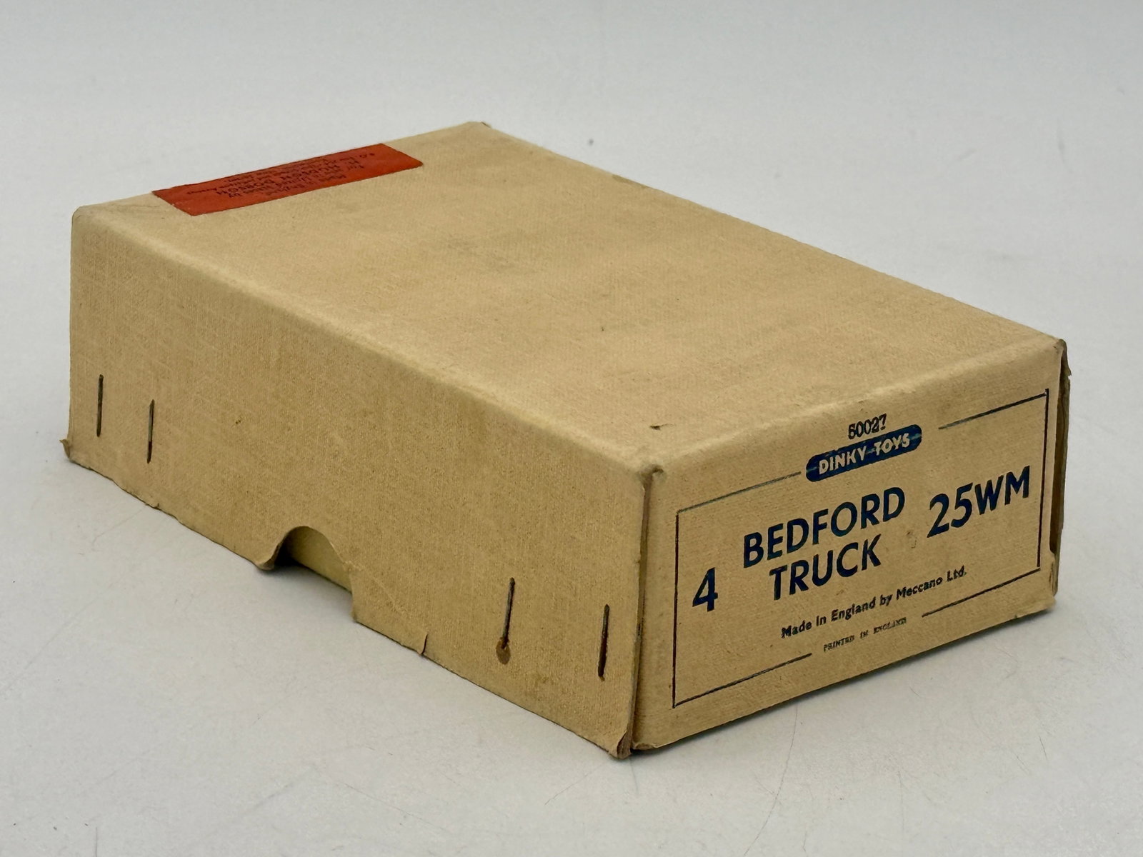 4 Dinky Toys No. 25WM Bedford Trucks in Original Trade Box: A group of Dinky Toys military Bedford trucks manufactured by Meccano Ltd. Each vehicle is constructed of die-cast metal with an olive drab finish, featuring open cabs and detailed cargo beds. The set