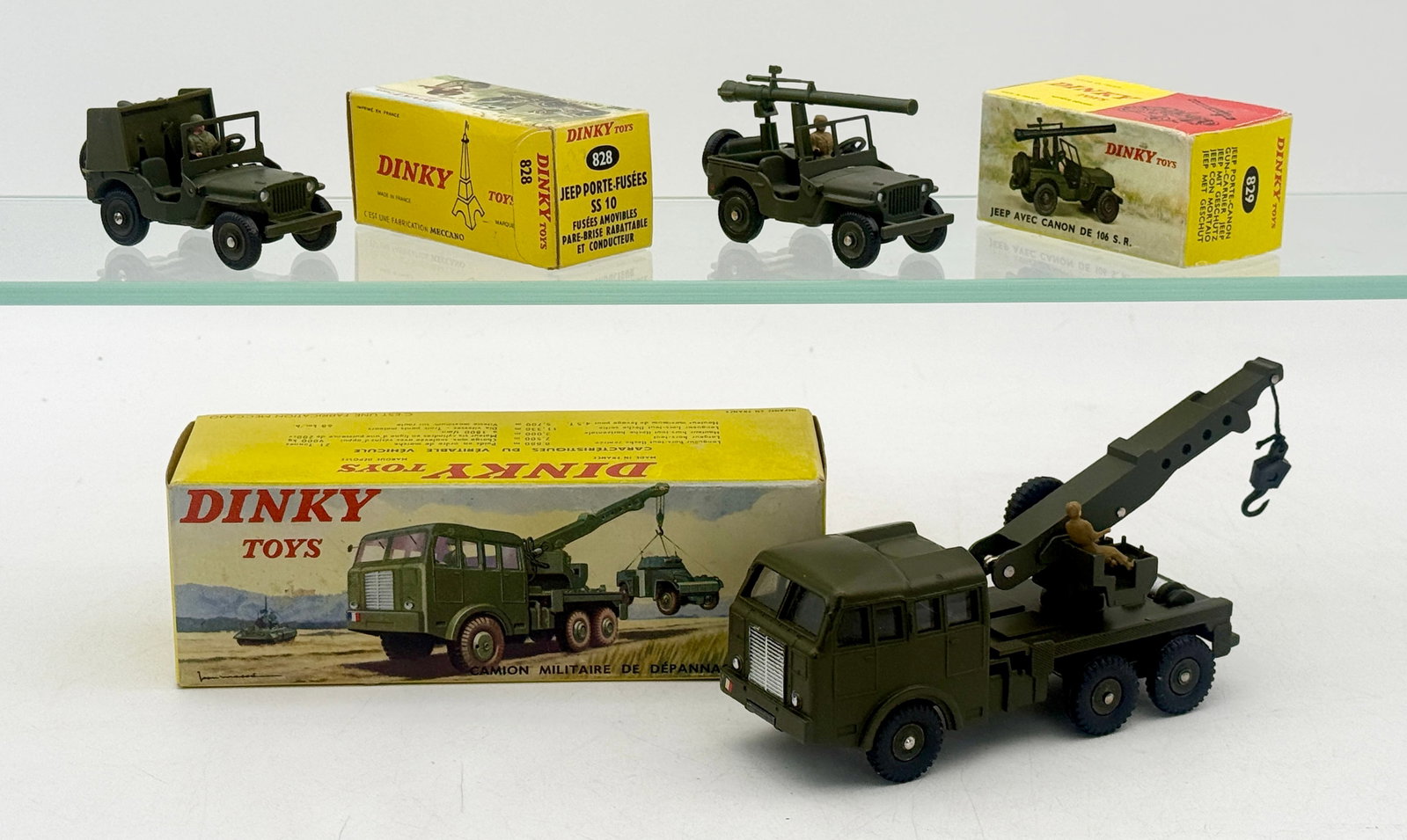 A Trio of French Dinky Toys Die-Cast Military Vehicles: A trio of French Dinky Toys die-cast military vehicles produced by Meccano, comprising a Berliet recovery crane and tactical Jeeps. The olive drab models feature functional components such as the swiv