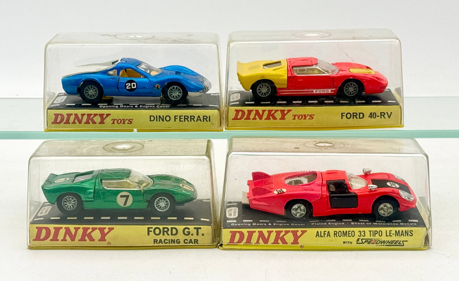 An Assortment of Dinky Toys Die-Cast Model Racing Cars: A collection of Dinky Toys die-cast model racing cars including a Dino Ferrari, Ford 40-RV, Ford G.T., and Alfa Romeo 33. Each vehicle is constructed with a metal body and plastic components, presente