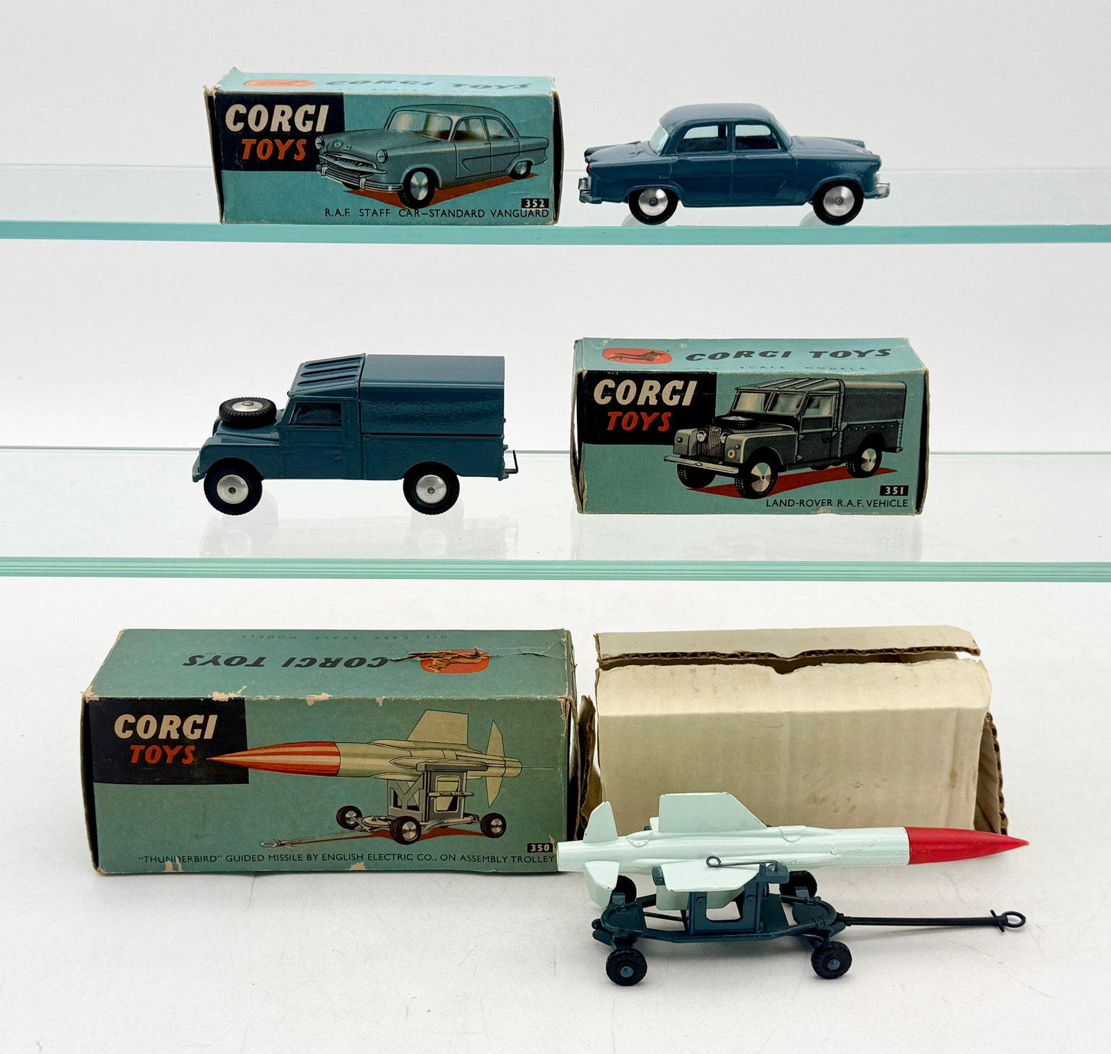 A Trio of Vintage Corgi Toys R.A.F. Die-Cast Model Vehicles: This trio of Corgi Toys features die-cast R.A.F. models including a Standard Vanguard staff car, a Land-Rover, and a Thunderbird guided missile. Each vehicle is finished in blue R.A.F. color and is ac