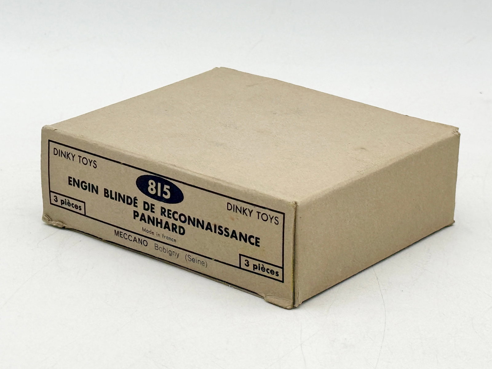 Dinky Toys 815 Panhard E.B.R. Armored Cars in Trade Box: A trio of Dinky Toys model 815 Panhard E.B.R. armored cars constructed from die-cast metal with original yellow picture boxes and a tan trade box. These olive drab green military vehicles feature eigh