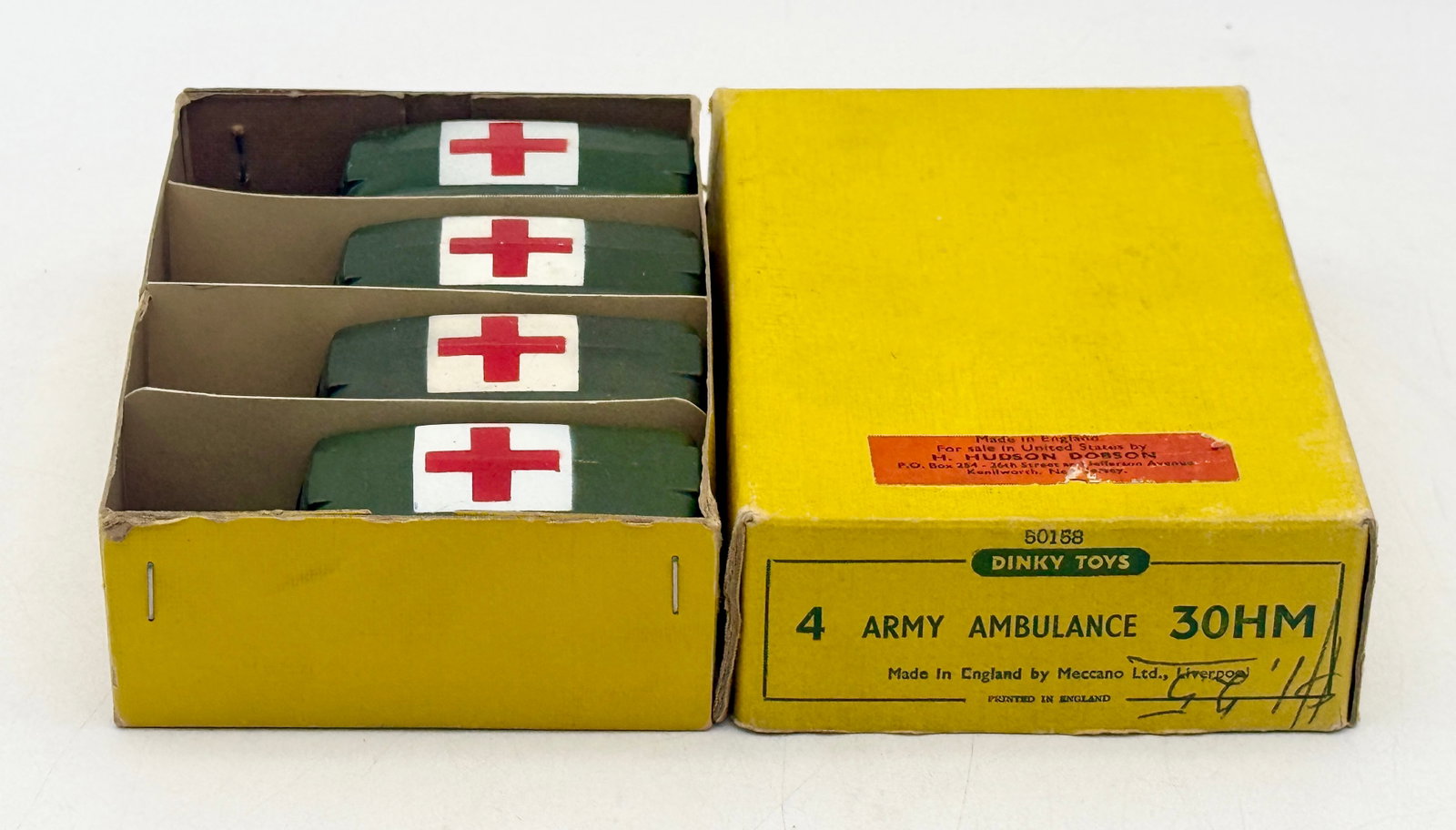 Dinky Toys 30HM Army Ambulance Set of 4 in Trade Box: A set of four Dinky Toys No. 30HM Army Ambulances manufactured by Meccano Ltd. in Liverpool, England. Each die-cast vehicle is finished in olive drab with red cross insignia on the roof, sides, and re