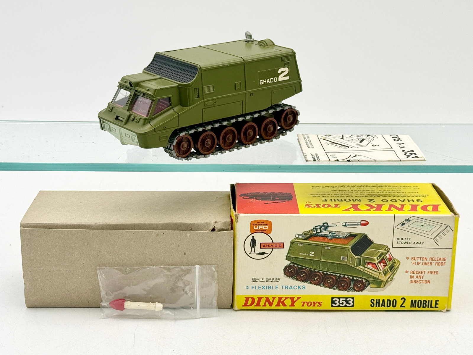 Dinky Toys 353 Shado 2 Mobile with Original Box: A Dinky Toys 353 Shado 2 Mobile die-cast vehicle based on the television show UFO. The model features olive green paint, brown wheels, and black flexible tracks. It is offered with the original pictor