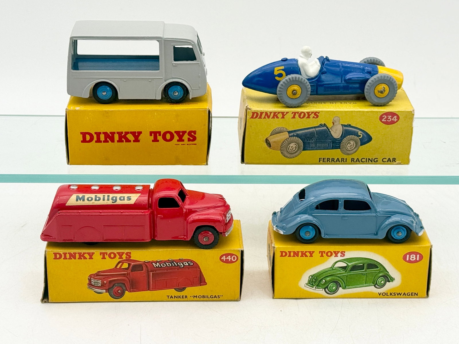 A Collection of Vintage Dinky Toys Die-Cast Model Vehicles: A collection of Dinky Toys by Meccano Ltd. featuring die-cast metal construction and original yellow cardboard picture boxes. The assortment includes a blue Volkswagen Beetle (181), a red Mobilgas Tan