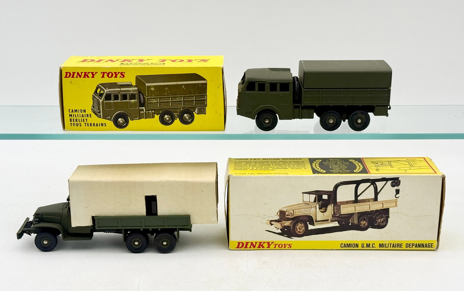 Two French Dinky Toys Die-Cast Military Trucks with Boxes: Two vintage die-cast metal military trucks manufactured in France by Dinky Toys. The lot includes a No. 818 Berliet all-terrain truck and a No. 808 GMC military recovery truck with a black crane assem