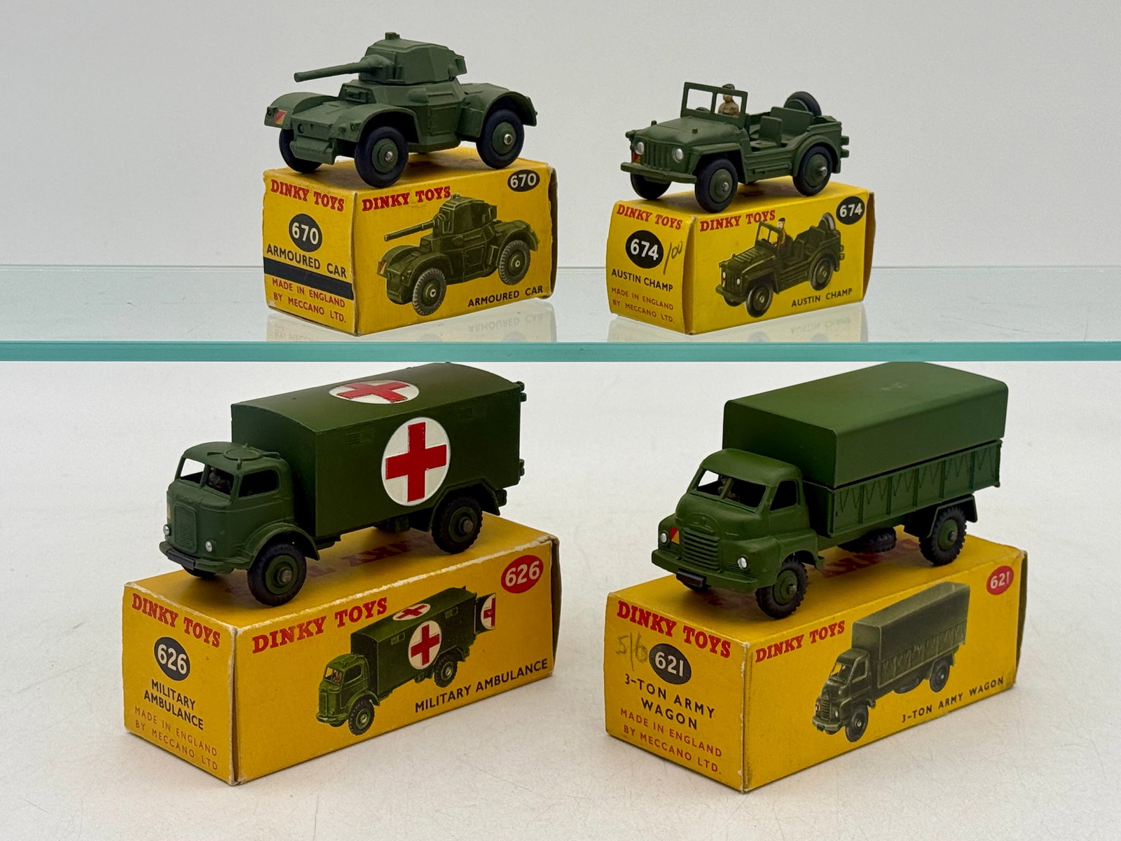 A Collection of Boxed Dinky Toys Military Die-Cast Vehicles: This collection of Dinky Toys military vehicles features die-cast models including a No. 621 3-Ton Army Wagon, No. 626 Military Ambulance, No. 670 Armoured Car, and No. 674 Austin Champ. Each model is