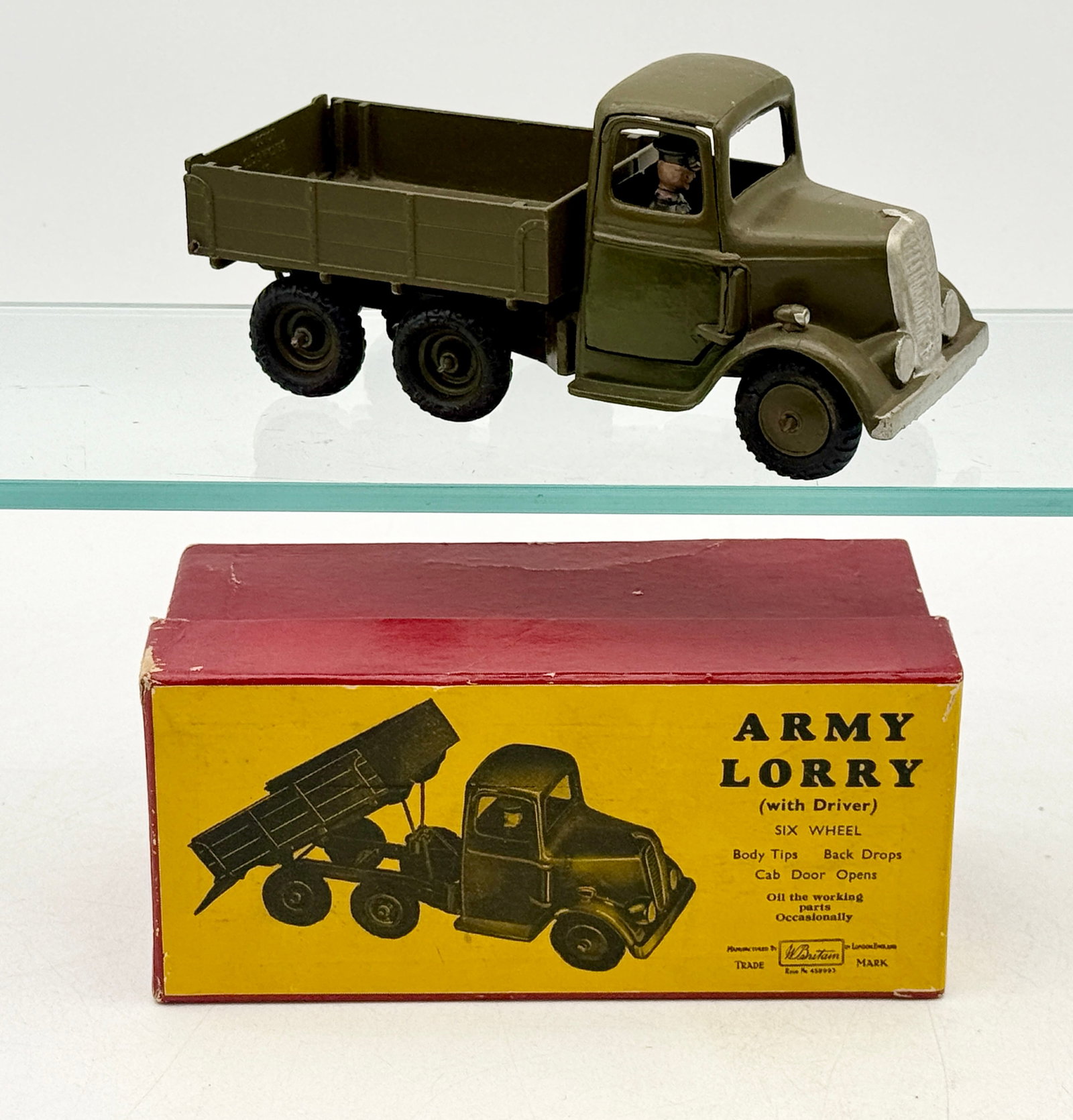 Britains No. 1335 Six-Wheel Army Tipping Lorry with Box: This W. Britain No. 1335 die-cast metal six-wheel army lorry features an olive drab finish with silver-painted accents on the radiator and headlights. The vehicle includes an opening driver-side door 