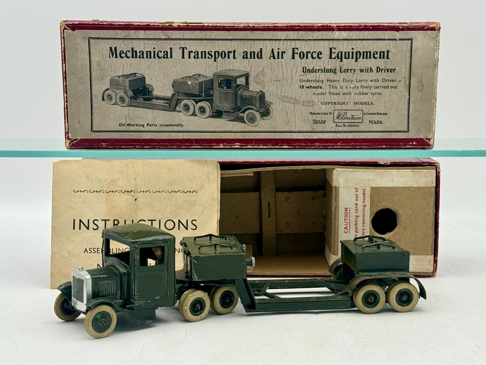 W. Britain Boxed No. 1641 Underslung Lorry with Driver: This W. Britain model number 1641 features a die-cast metal underslung lorry finished in olive green with a seated driver figure. The eighteen-wheeled vehicle retains its original rubber tires and is 