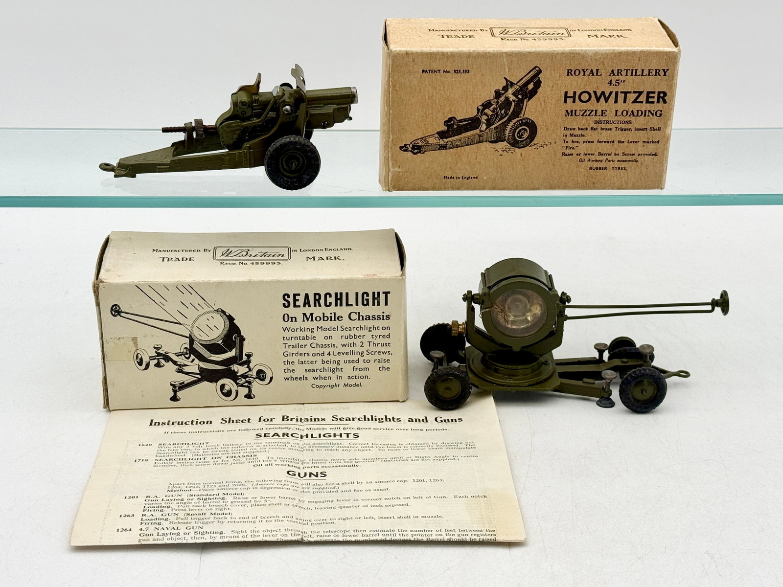 Two Vintage Boxed W. Britain Die-Cast Military Models: This lot features a Royal Artillery 4.5 inch Howitzer No. 1725 and a Searchlight on Mobile Chassis No. 1718, both manufactured by W. Britain in London. Each model is constructed from die-cast metal fi