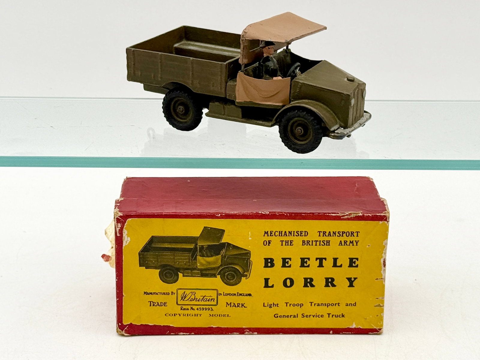 W. Britain No. 1877 Beetle Lorry with Original Illustrated Box: This W. Britain No. 1877 Beetle Lorry is a die-cast metal military vehicle finished in olive drab paint with a removable tan canopy and driver. The model features a rear tow hitch and includes its ori