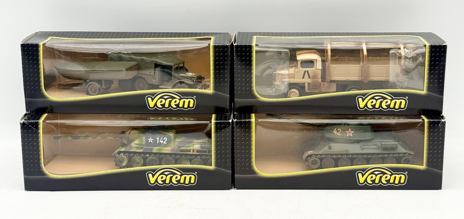 Four Verem Boxed 1:50 Scale Die-Cast Military Vehicles: This collection of four Verem die-cast military models includes a Dodge 6x6 with pontoon trailer, a Berliet GBC truck, an SU-100 tank destroyer, and a T-34/85 tank. Each 1:50 scale vehicle is housed i