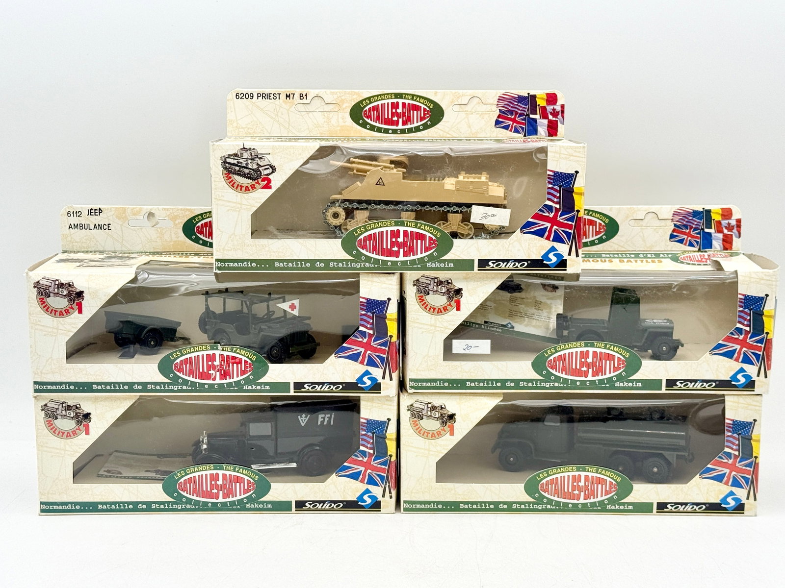 A Group of Solido Les Grandes Batailles Die-Cast Military Vehicles: A collection of Solido die-cast military vehicles from the Les Grandes Batailles series featuring various WWII models in original packaging. The group includes a tan M7 Priest self-propelled gun, a Je