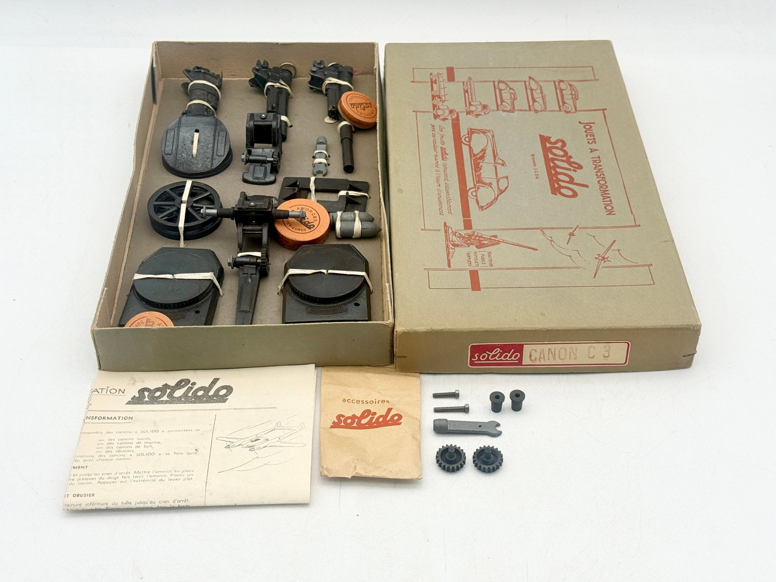 Solido Canon C3 Transformation Artillery Set in Original Box: A vintage Solido Canon C3 transformation artillery set constructed of die-cast metal components. The set includes interchangeable barrels, wheels, and adjustable bases secured in the original illustra