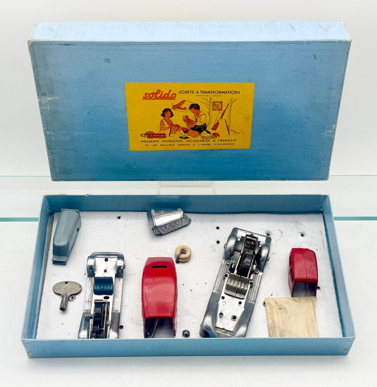 A Vintage Solido Jouets ? Transformations Die-Cast Metal Toy Set: This vintage Solido Jouets à Transformations set consists of French-made die-cast metal automotive components housed in the original light blue cardboard box. The collection includes interchang