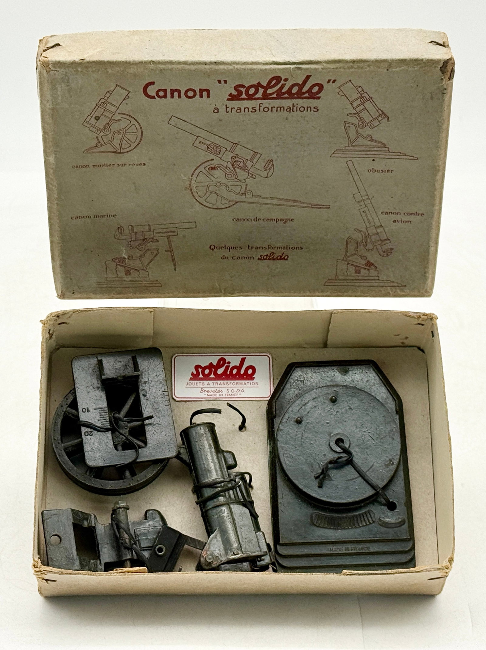 Vintage Solido Canon K Transformable Die-Cast Artillery Toy Set: This Solido Canon K set features various die-cast metal components designed to be assembled into several artillery configurations including a field gun, mortar, and howitzer. The collection is housed 