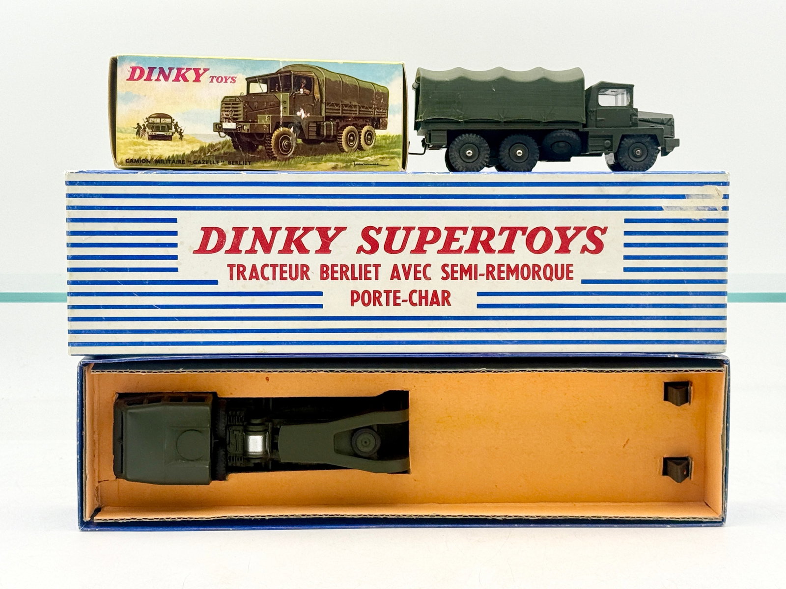 Two French Dinky Toys Military Berliet Vehicles with Original Boxes: Two French Dinky Toys and Supertoys military die-cast vehicles comprise this lot, featuring a Berliet Gazelle truck and a larger Berliet tractor with semi-trailer tank transporter. Both models are fin