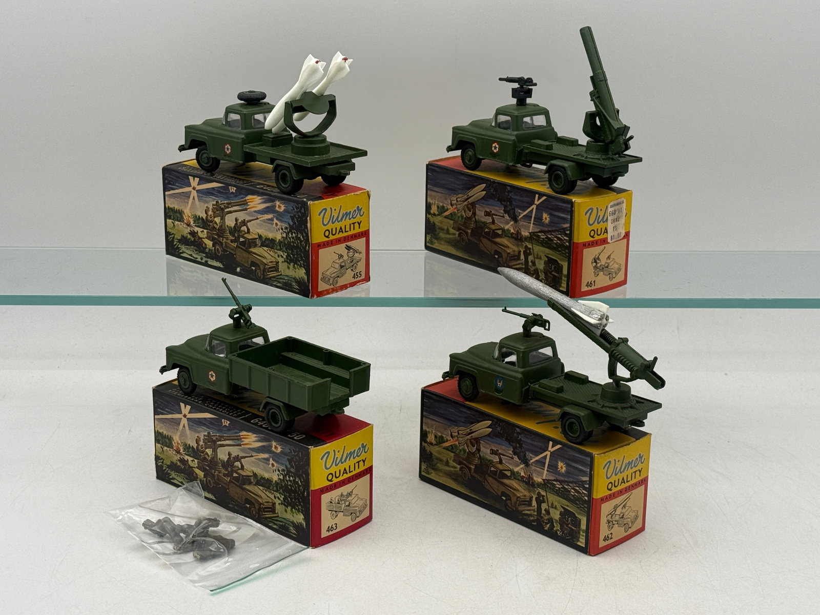 A Group of Vintage Vilmer Die-Cast Chevrolet Military Trucks: A group of vintage Vilmer 1:50 scale die-cast Chevrolet military trucks manufactured in Denmark. Each green-painted metal vehicle features unique plastic and metal armaments including missile launcher